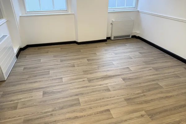Wood-effect vinyl with cap and cove around the skirting in a nursery room