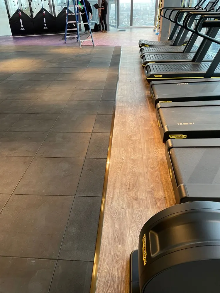 Rubber tiles and a wood-effect run under the treadmills in a commercial gym
