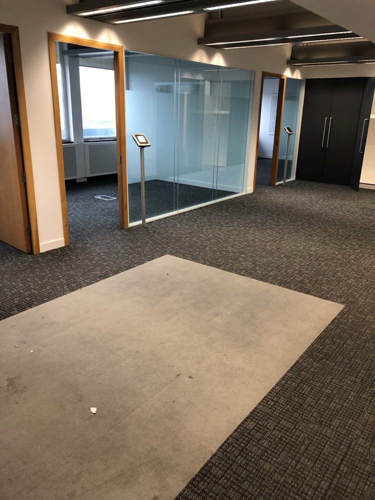 Commercial office floorplate with carpet tiles and glass meeting rooms