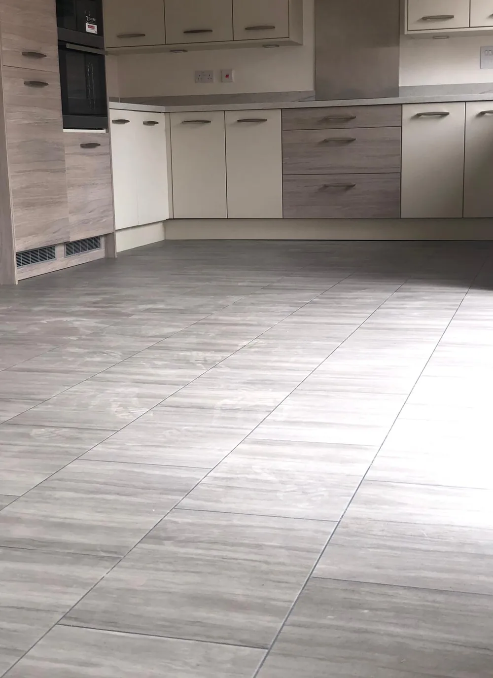 Stone-effect tile flooring fitted across a kitchen floor