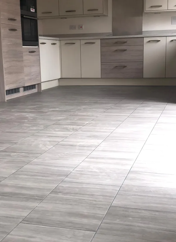 Stone-effect tile flooring fitted across a kitchen floor